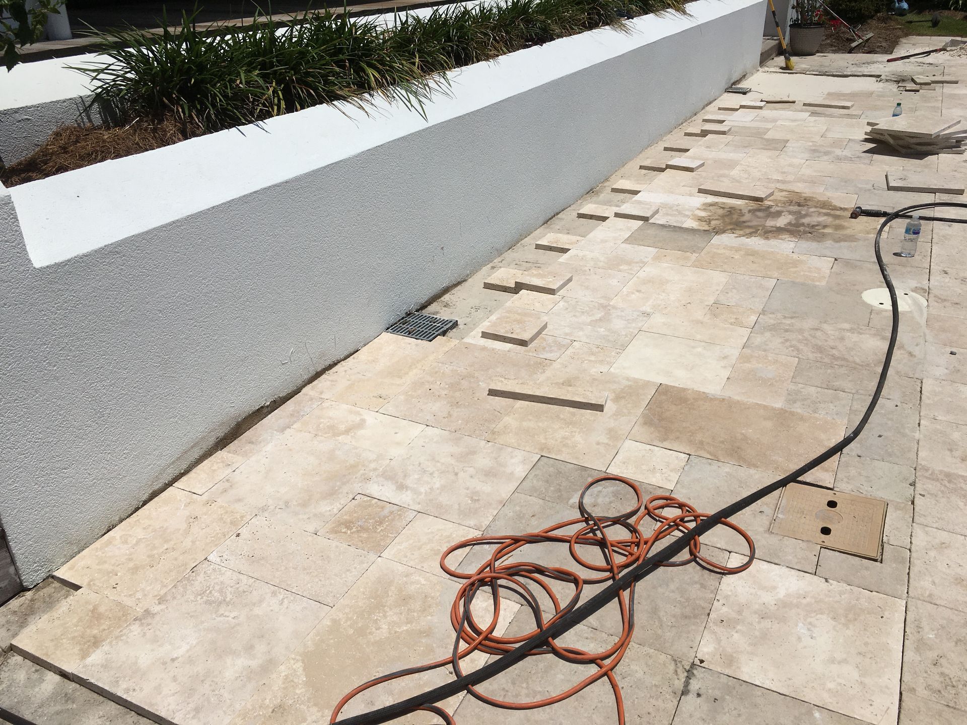 A hose is laying on the ground next to a wall