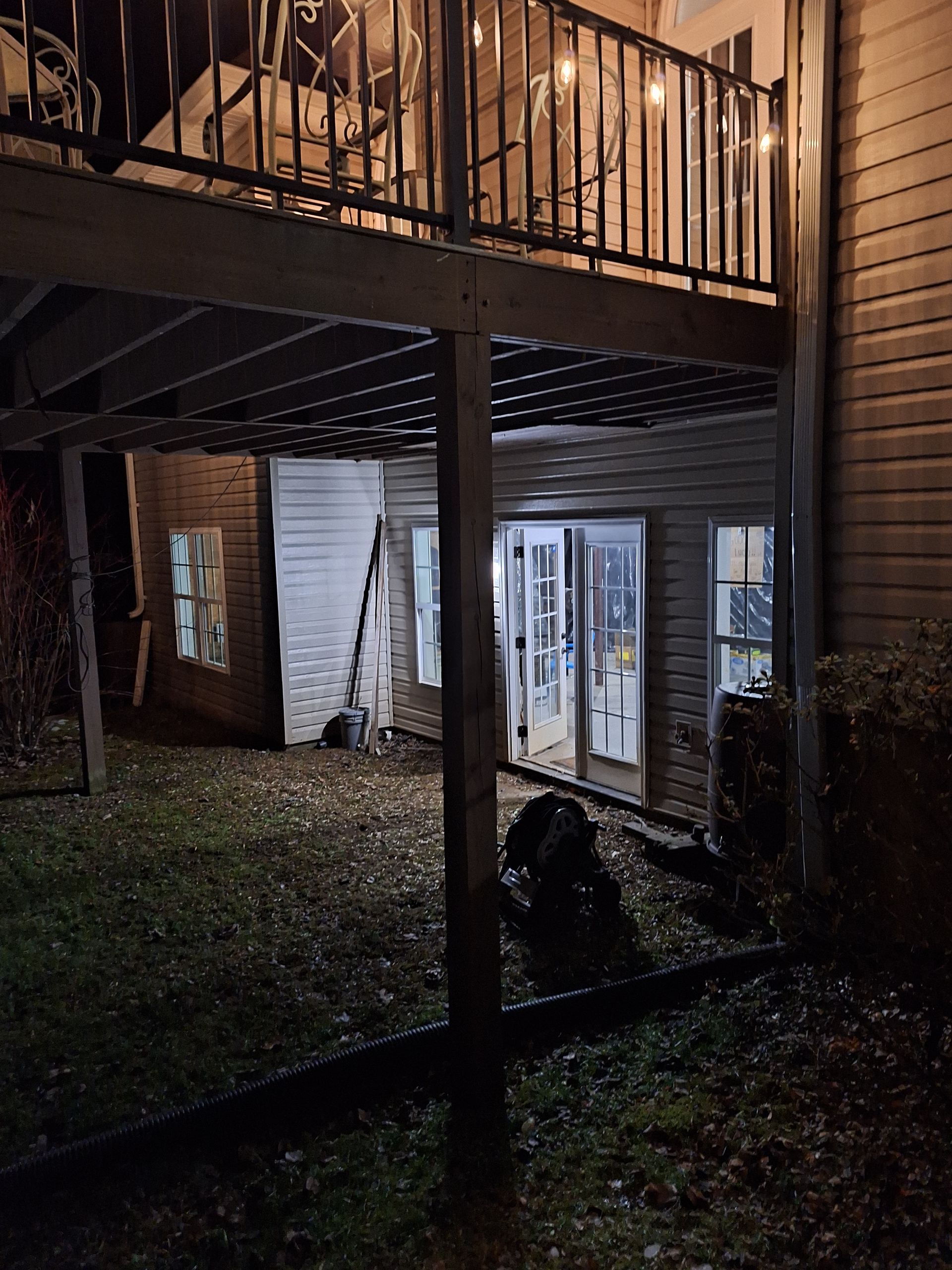 The back of a house with a deck and a balcony at night