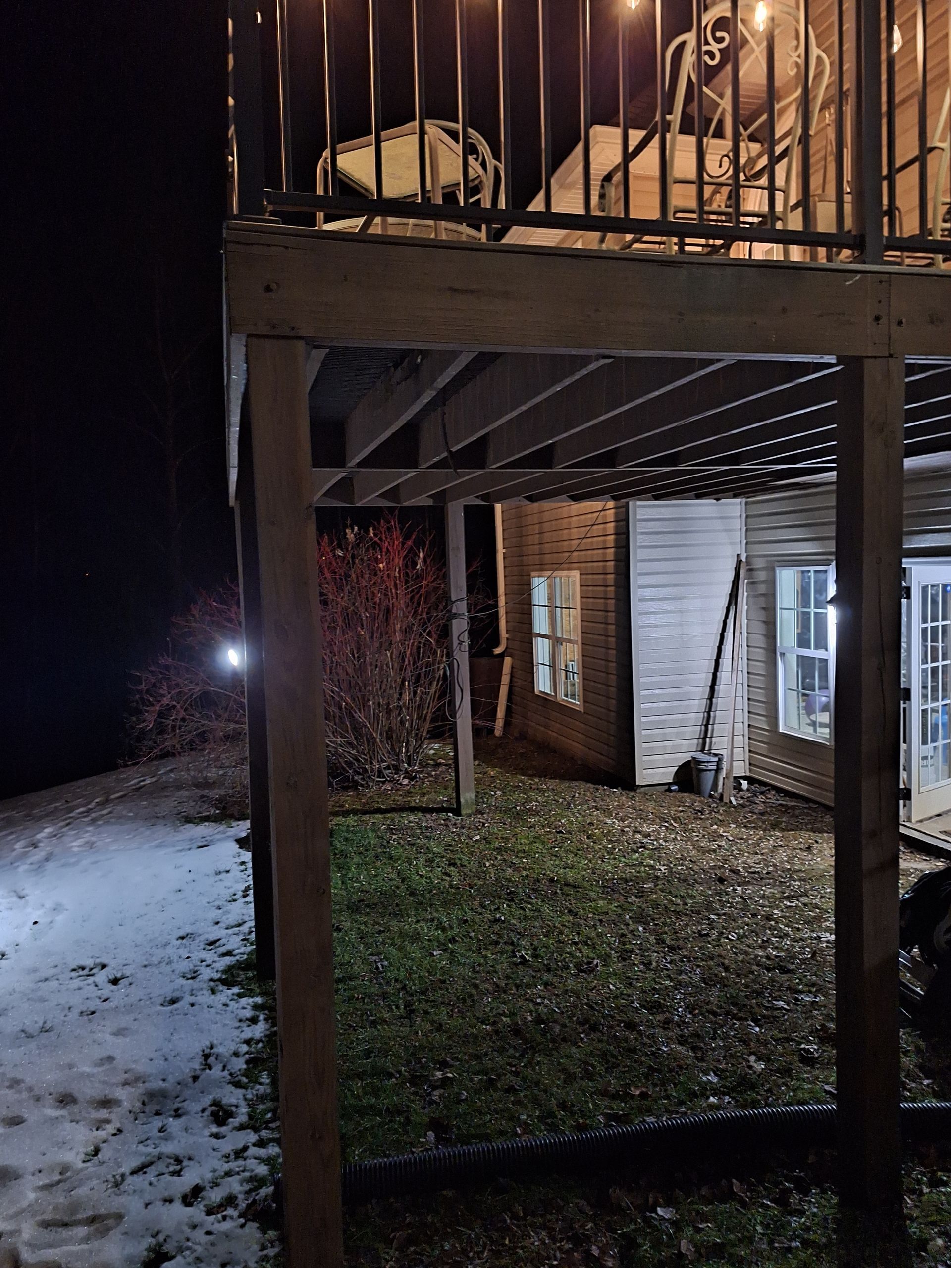 A house with a balcony on top of it at night