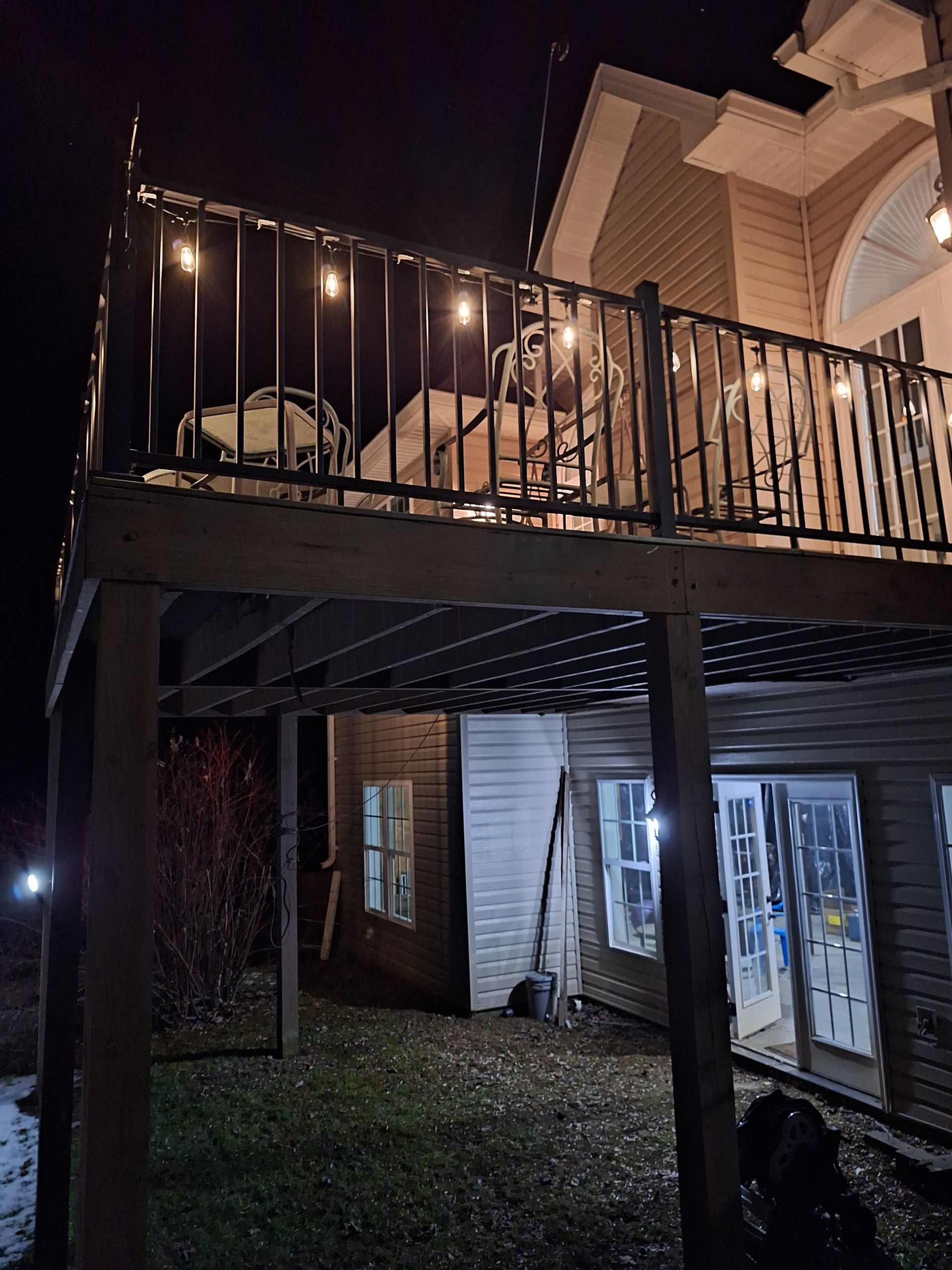A house with a balcony that is lit up at night