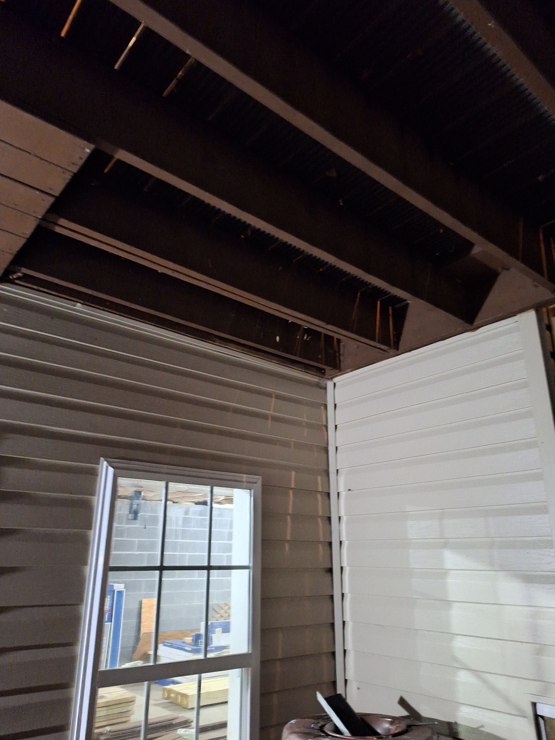 A room with a window and a wooden ceiling