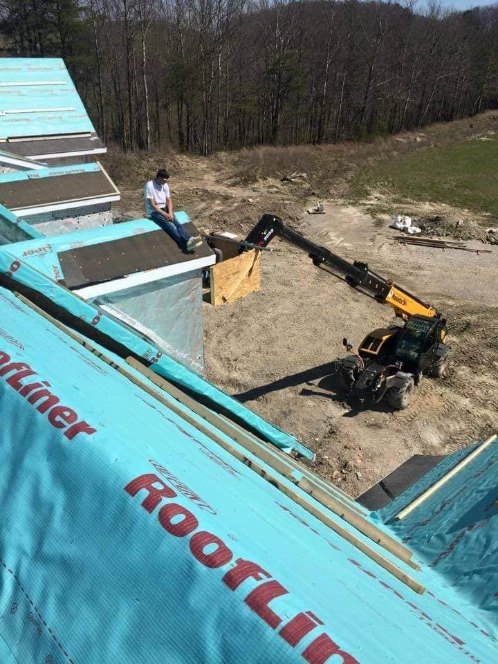 A man is working on a roof with a crane.