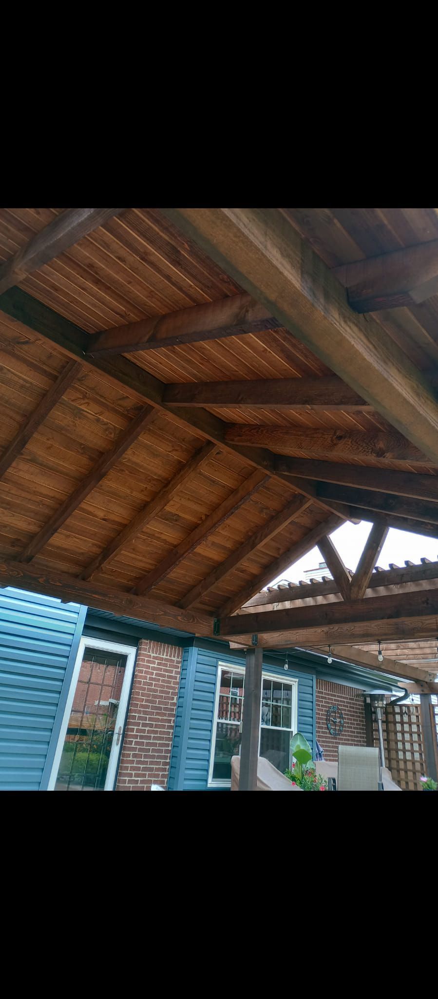 A wooden roof with a blue building in the background.