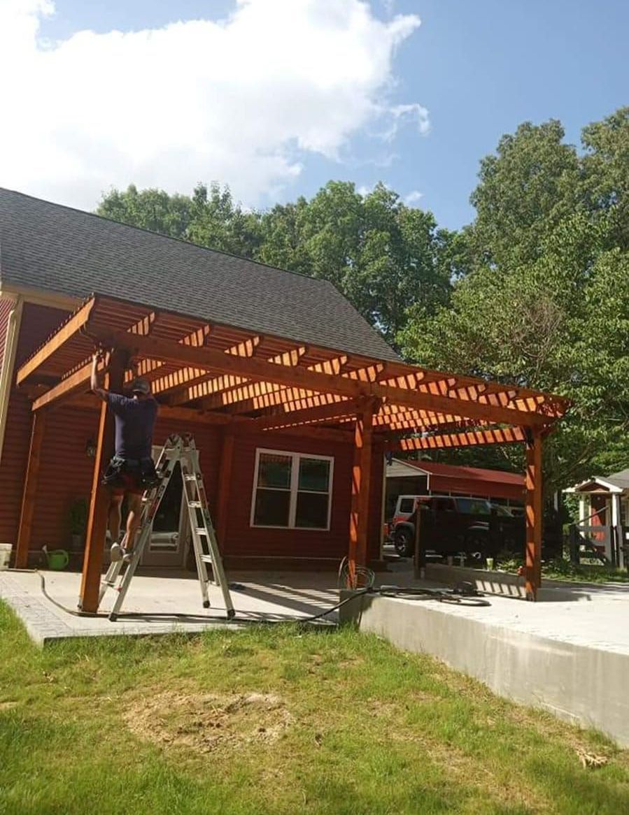 A man is standing on a ladder in front of a house.
