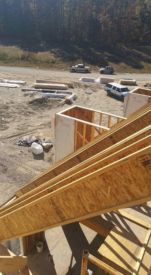 A wooden structure is being built on a dirt field.