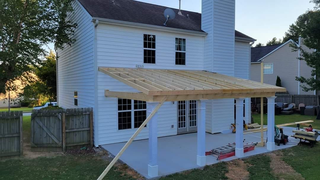 A white house with a wooden porch under construction.