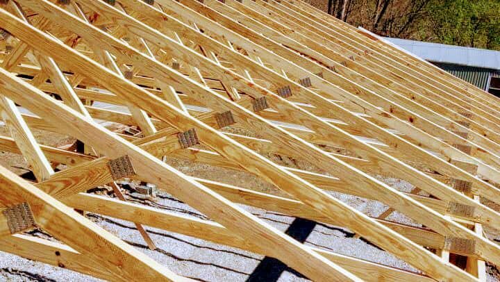 A roof is being built with wooden beams.