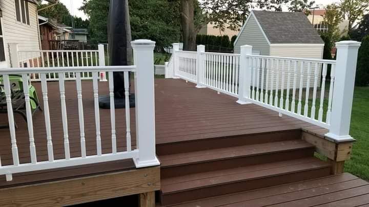 A wooden deck with stairs and a white railing.