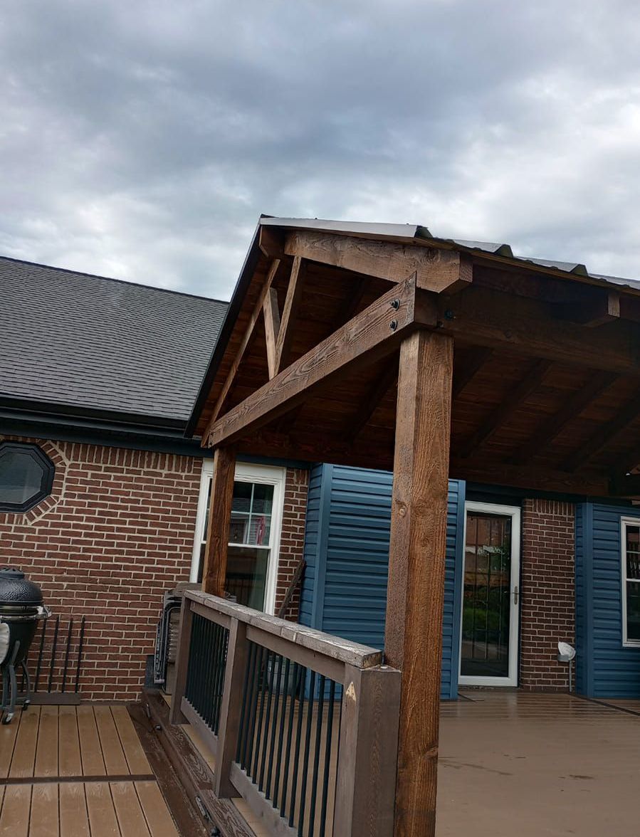 A brick house with a wooden porch and blue shutters.