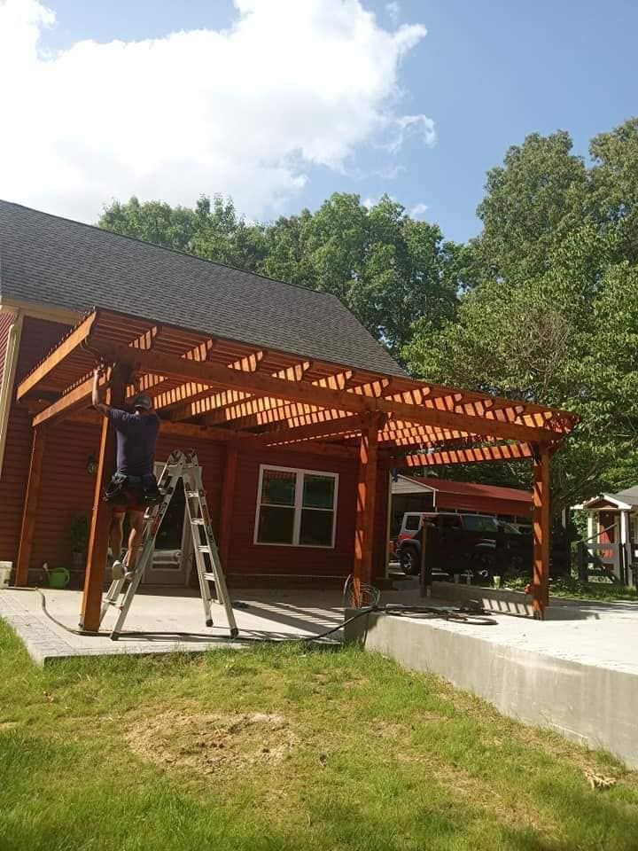 A wooden pergola is being built in front of a house.