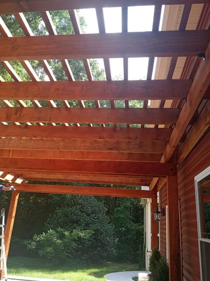 A red house with a wooden pergola over it