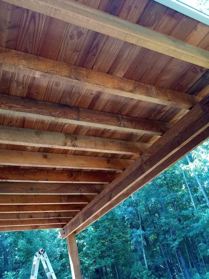 The ceiling of a wooden deck with a ladder in the background.