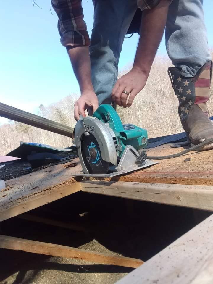 A man is using a circular saw to cut a piece of wood.