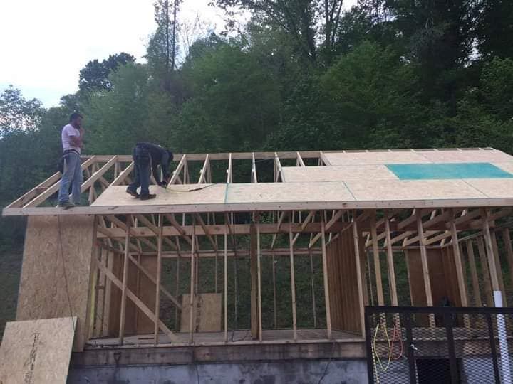 Two men are working on the roof of a house