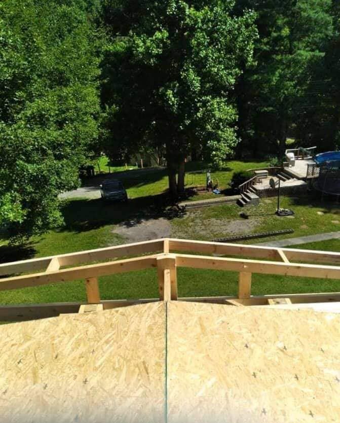 A roof that is being built with trees in the background