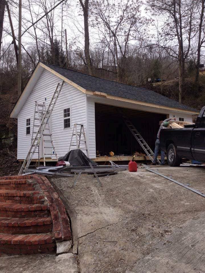 A truck is parked in front of a garage under construction.