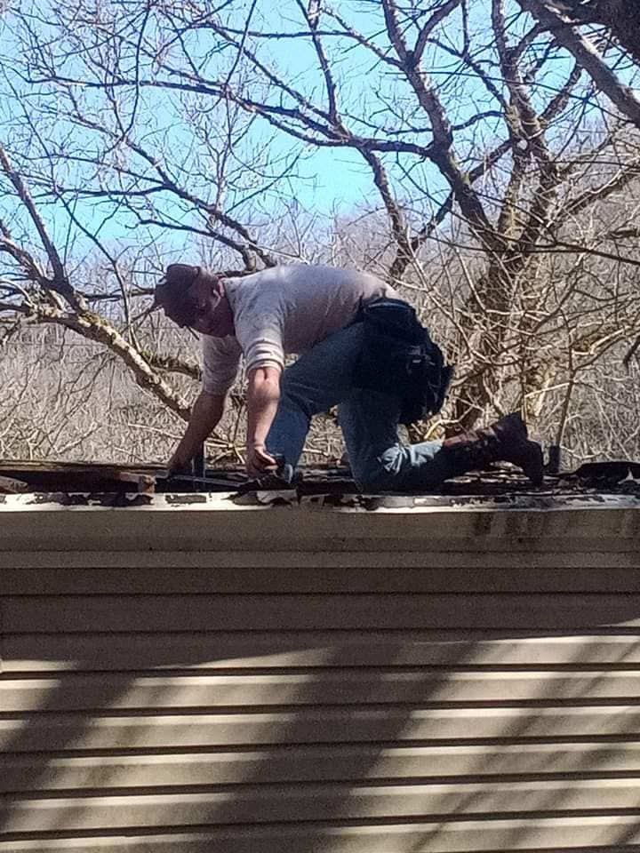 A man is working on the roof of a house.