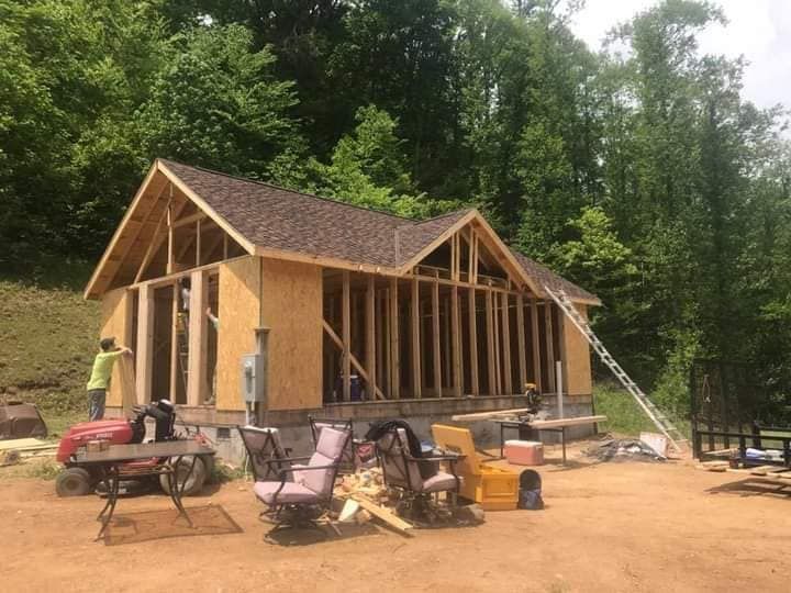 A house is being built in the middle of a dirt field.
