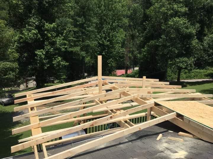 A wooden structure is being built on top of a roof.