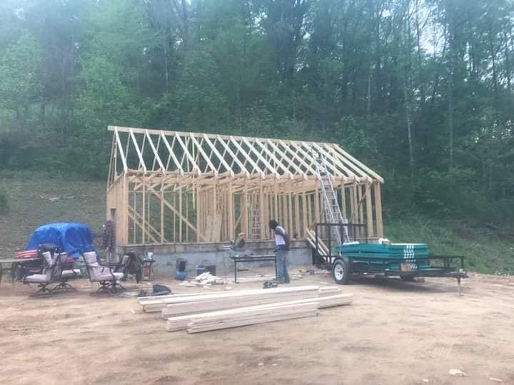 A man is standing in front of a building under construction.
