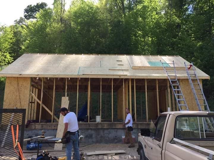 A truck is parked in front of a house under construction.