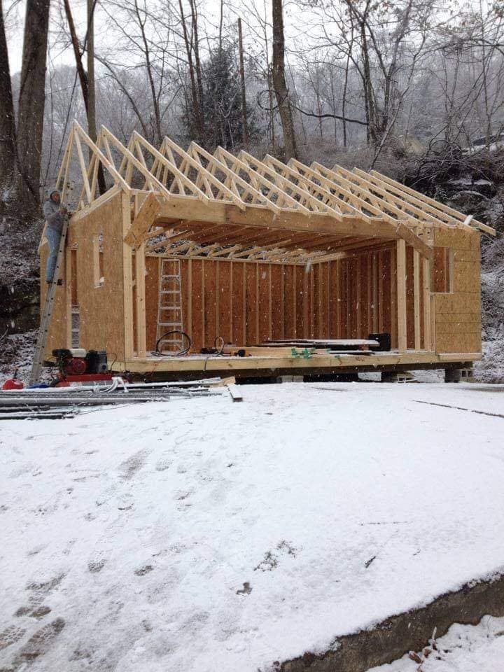 A wooden structure is being built in the snow.