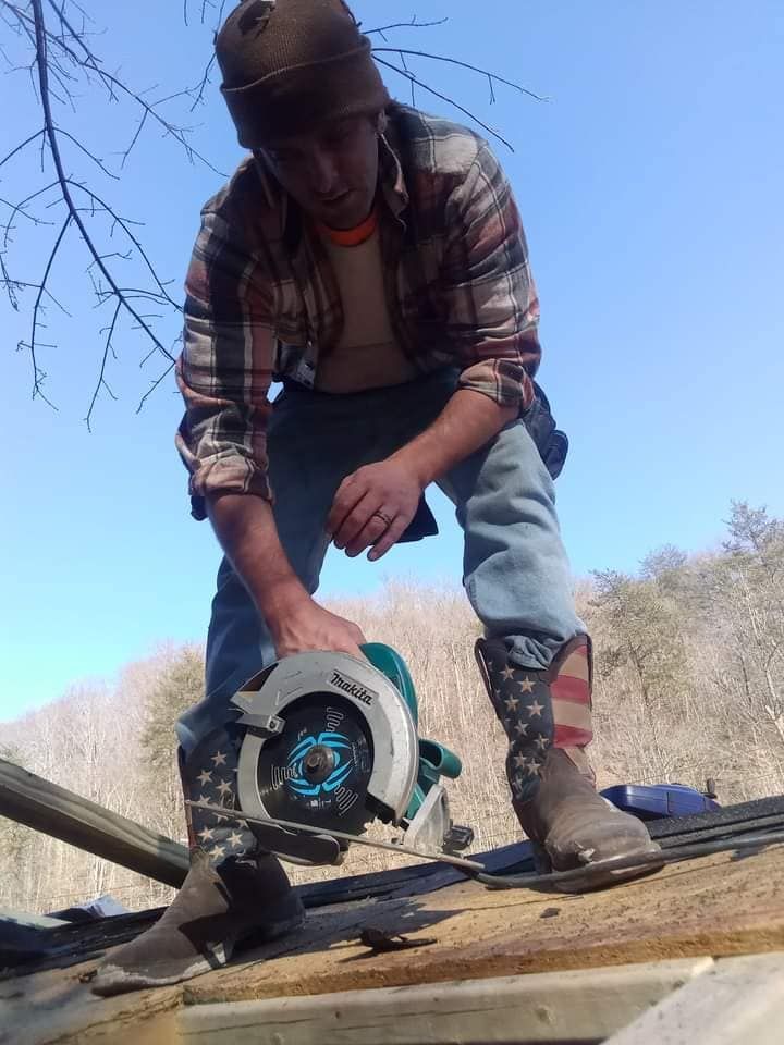A man wearing cowboy boots is using a circular saw
