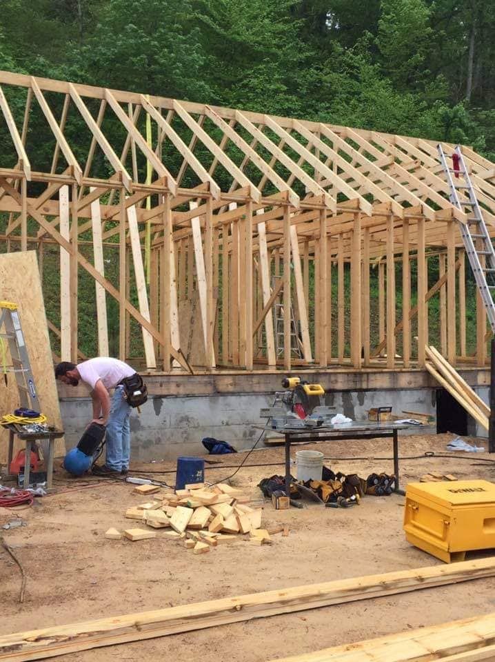 A man is working on the roof of a building under construction.
