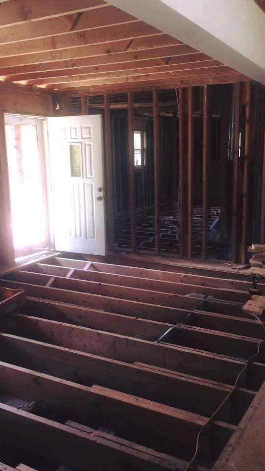 A room with a door and a wooden floor under construction.