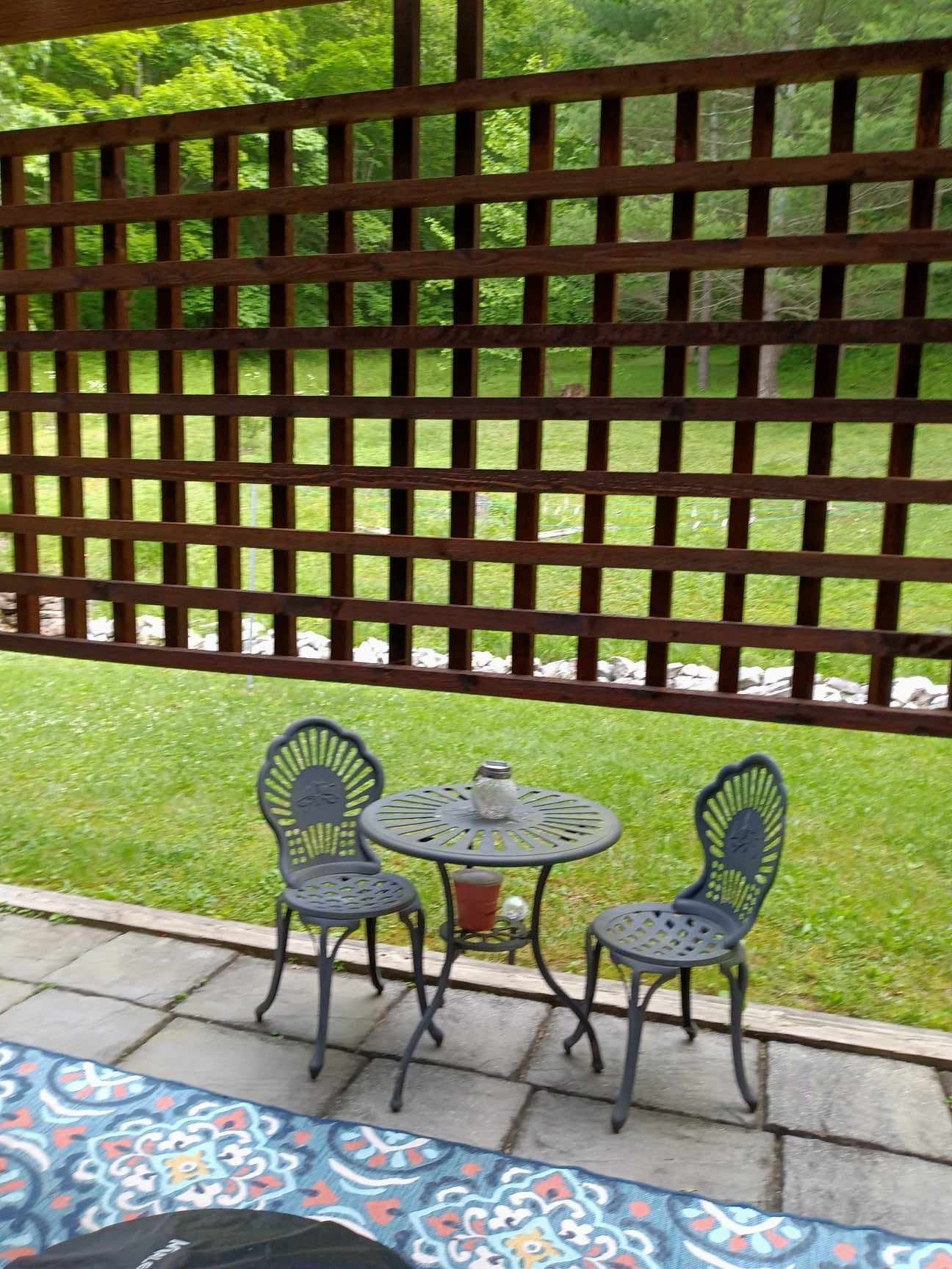 A table and chairs are sitting on a patio under a pergola.