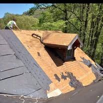 A man is working on the roof of a house.