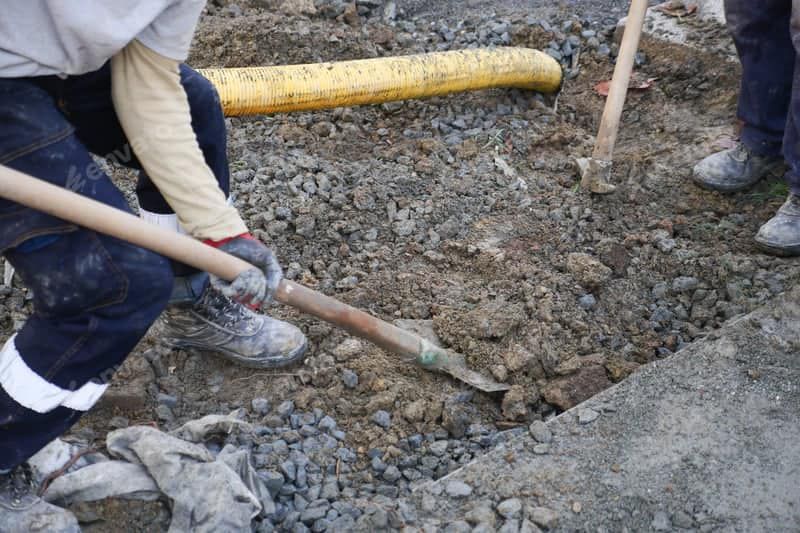 A person is using a shovel to dig a hole in the ground.