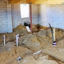 A room with a lot of dirt and pipes in it.