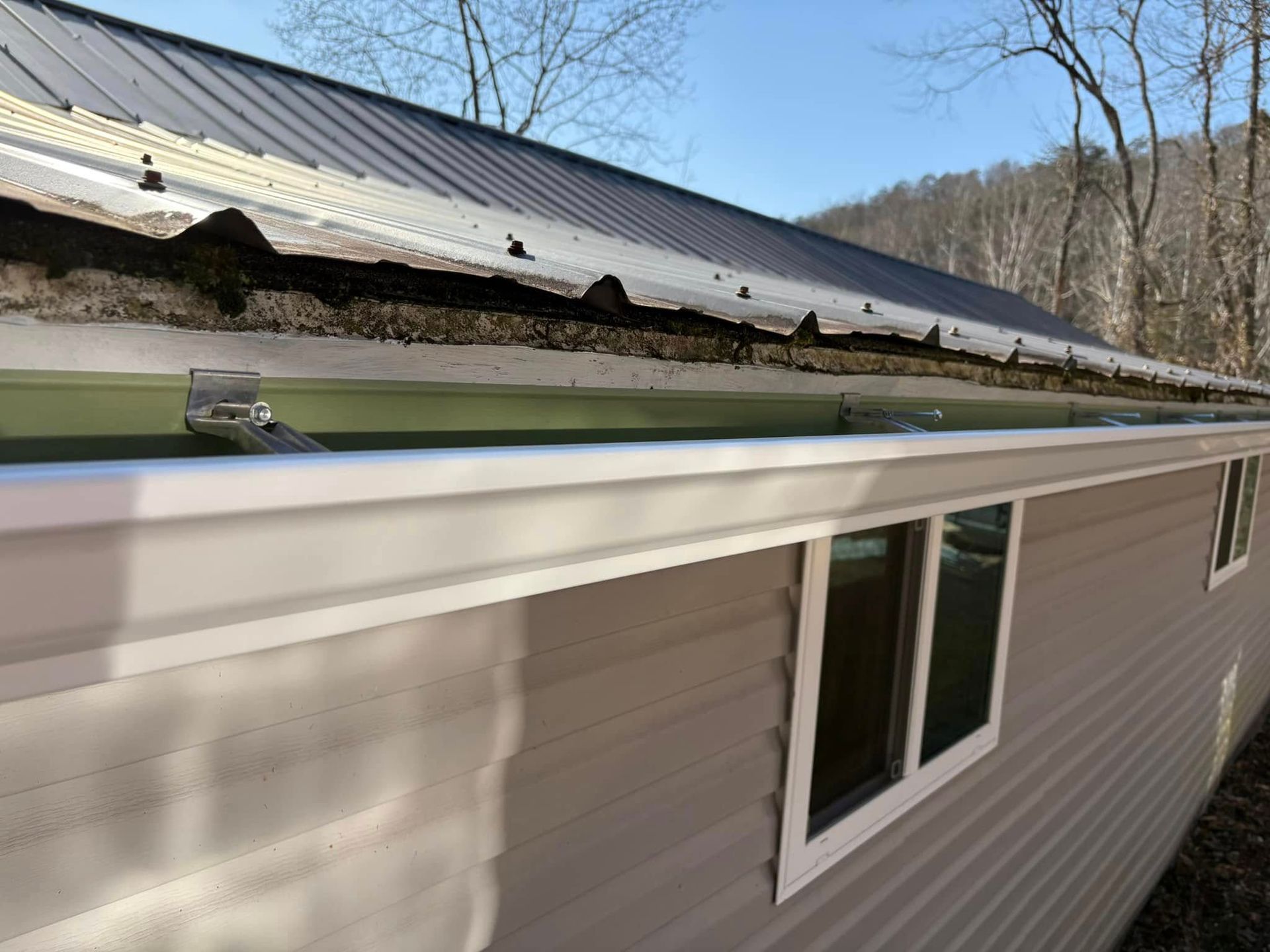 A house with a gutter on the side of it and a roof.