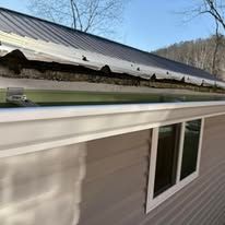 A house with a gutter on the side of it and a metal roof.