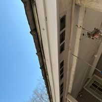 Looking up at the roof of a building with a blue sky in the background.