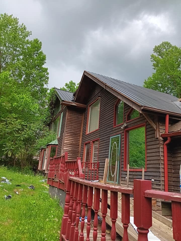 A wooden house with a red railing in front of it