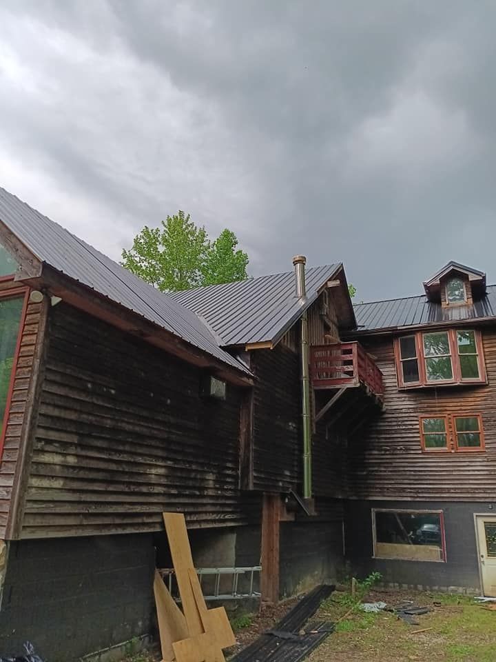 A large wooden house with a metal roof and a balcony