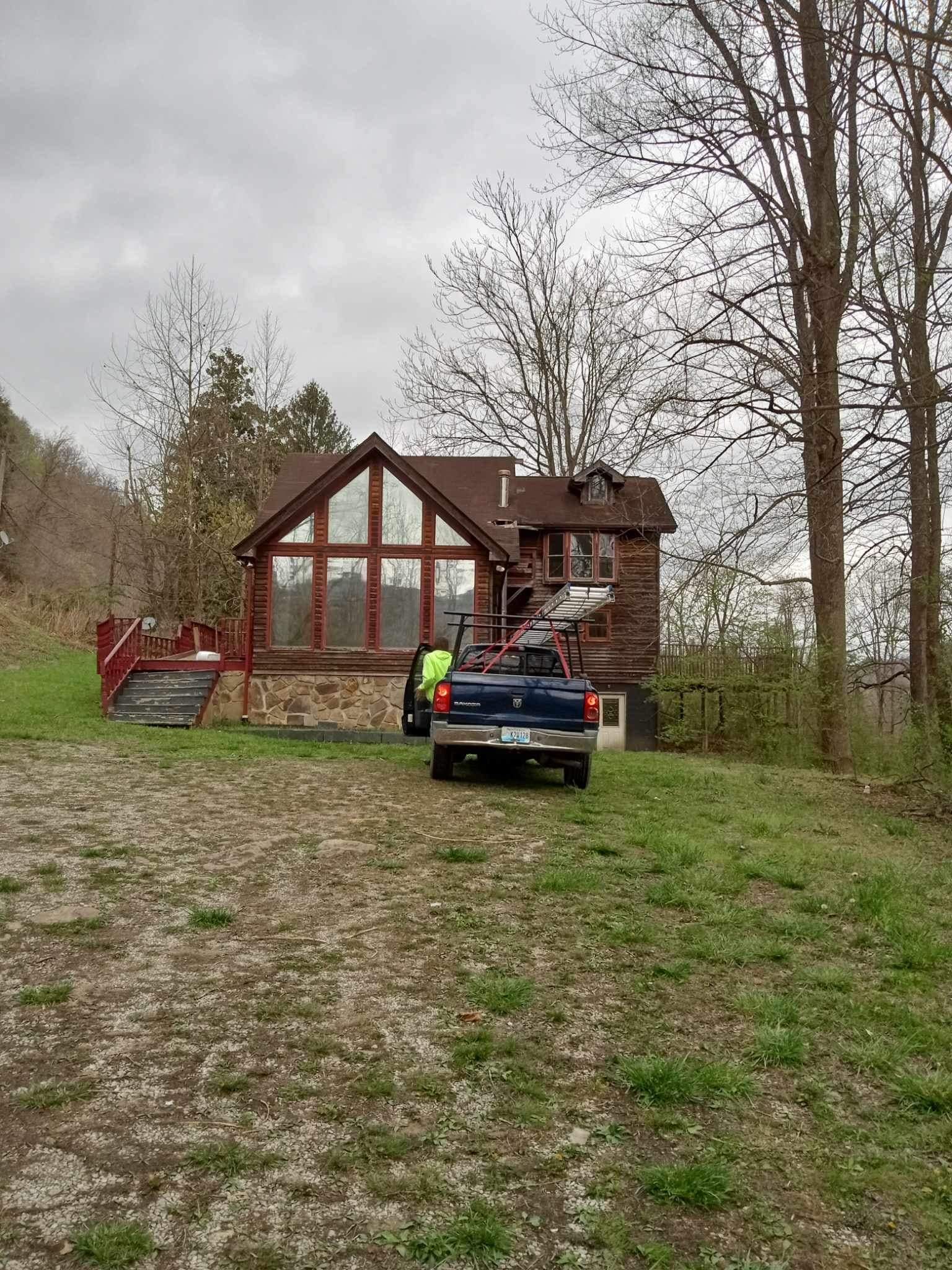 A truck is parked in front of a log cabin.