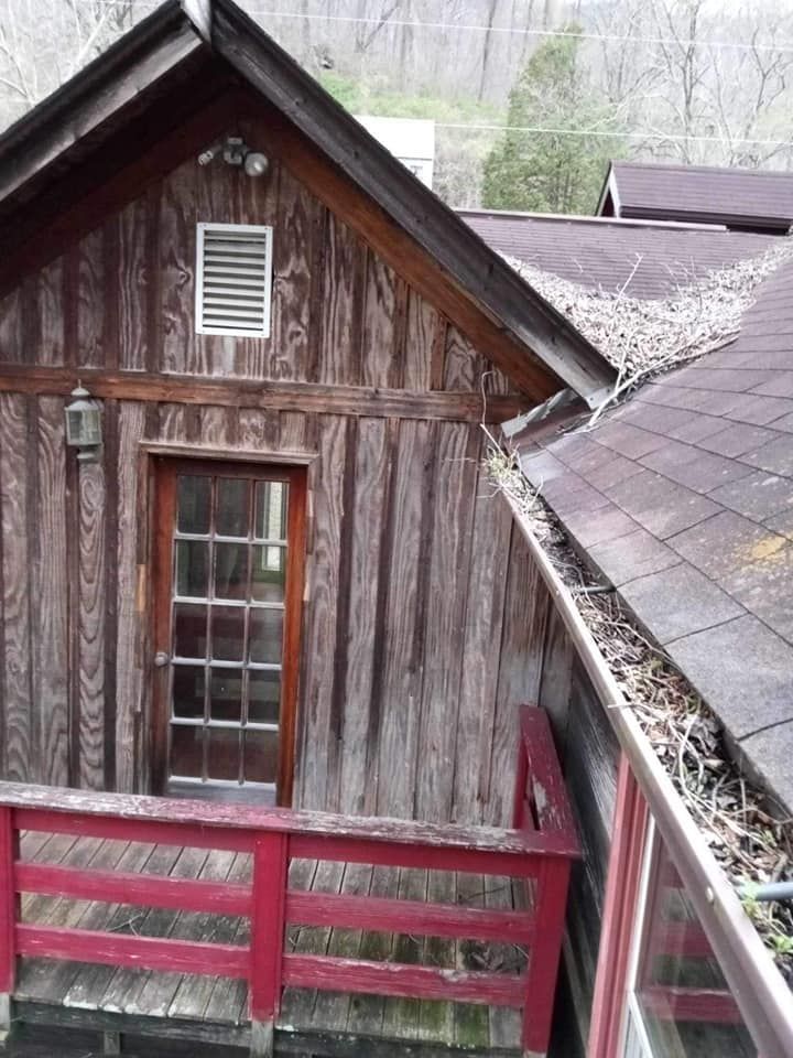 A wooden house with a red railing and a window
