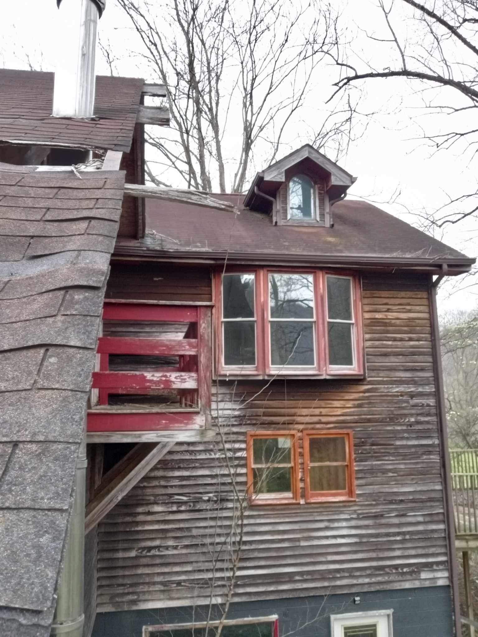 A wooden house with a chimney on the roof