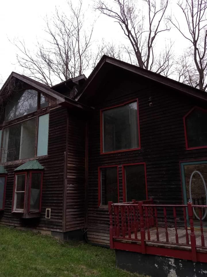 A large wooden house with a red deck and a lot of windows