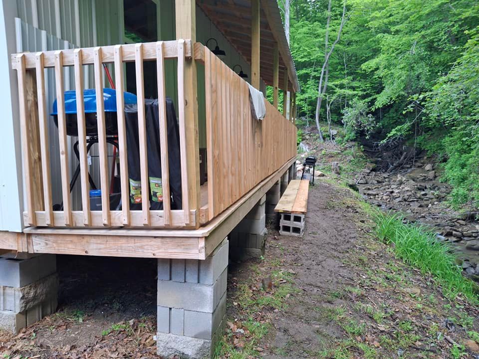 A wooden deck is sitting on top of concrete blocks next to a river.