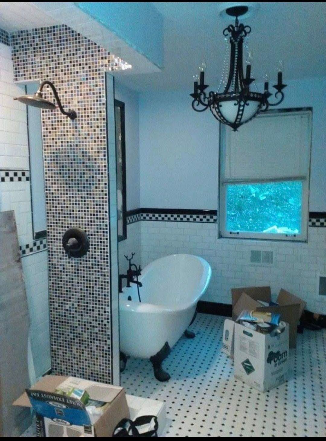 A bathroom with a tub and boxes on the floor