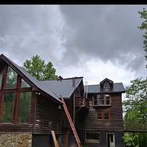 A large wooden house with a metal roof on a cloudy day.