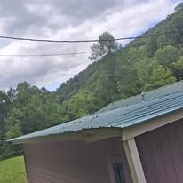 A purple building with a blue roof and a mountain in the background.