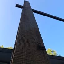 A close up of a wooden pole with a blue sky in the background.