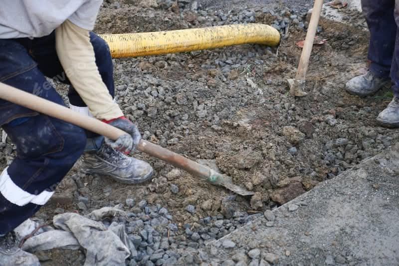 A person is using a shovel to dig a hole in the ground.