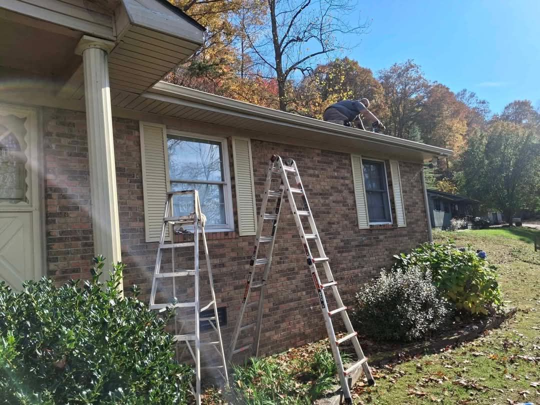 A ladder is sitting on the side of a brick house.