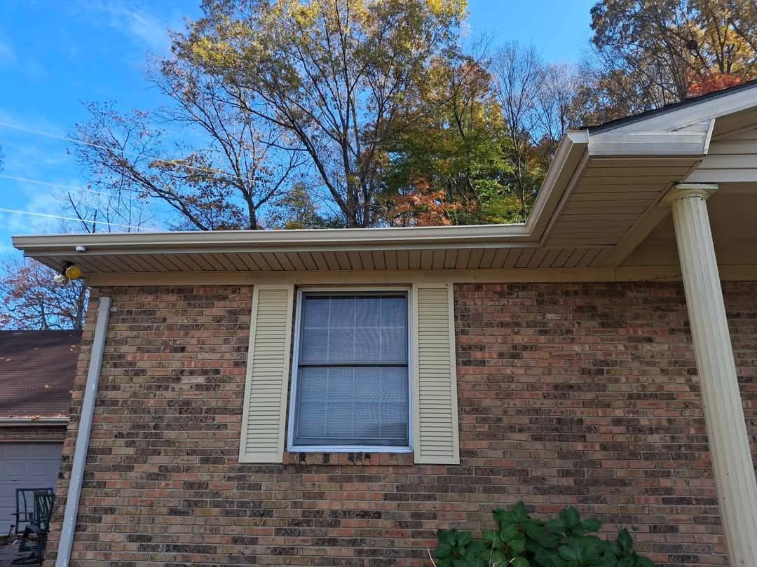 A brick house with a window and shutters on it.